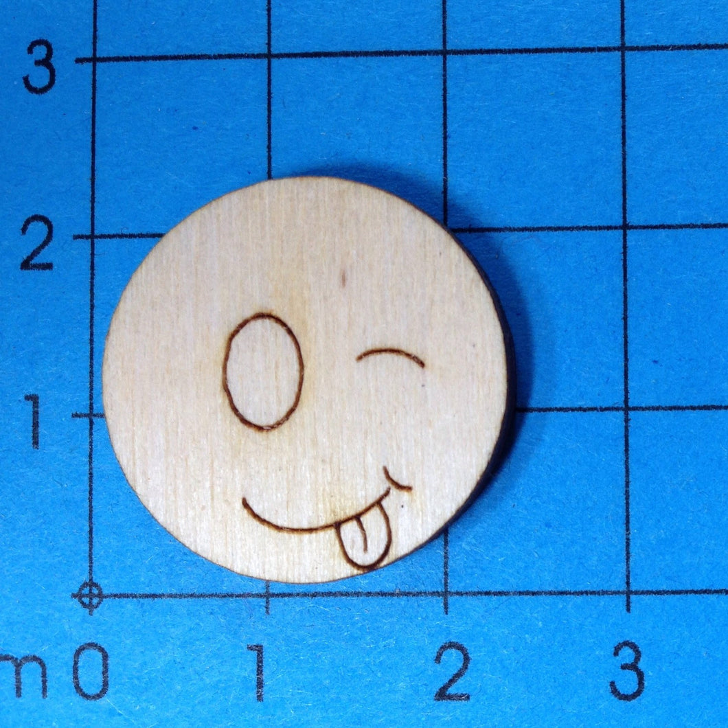 Button mit Gesicht aus Holz, zwinkernd und ausgestreckter Zunge